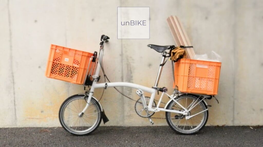 前後にカゴが取り付けられた折りたたみ自転車のブロンプトン